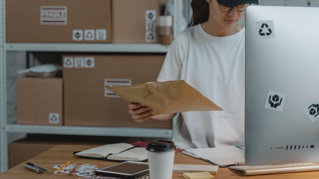 Small business owner processing sales for delivery to customers