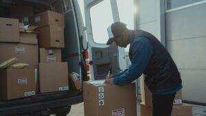 Delivery driver scanning packages to show three ways that background checks help gig work