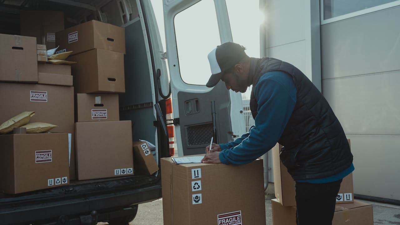 Delivery driver scanning packages to show three ways that background checks help gig work