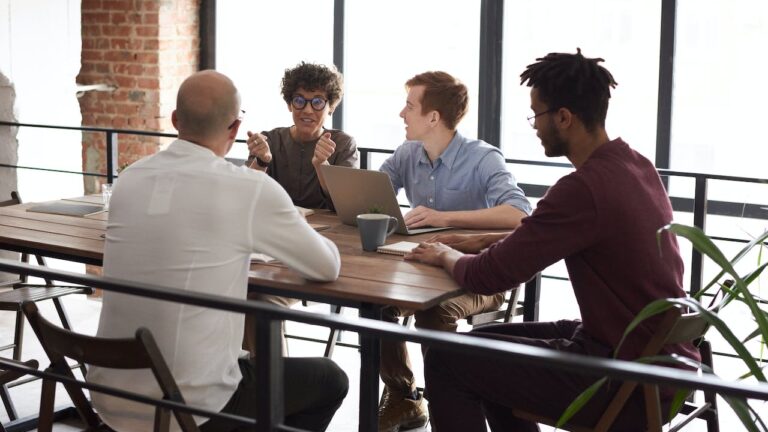 Happy team who improved hiring with background checks collaborative workplace meeting
