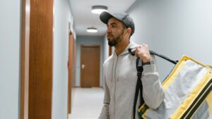 Male food delivery worker in hat in the gig and freelance economy in Canada