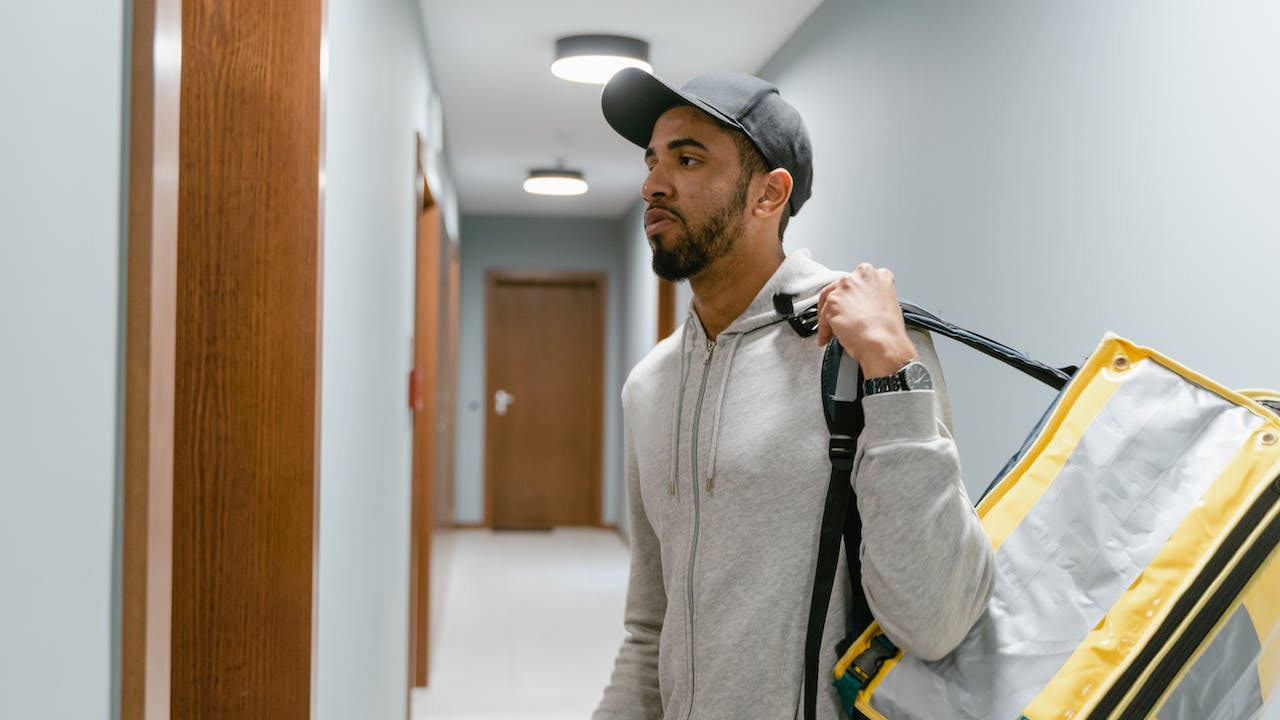 Male food delivery worker in hat in the gig and freelance economy in Canada