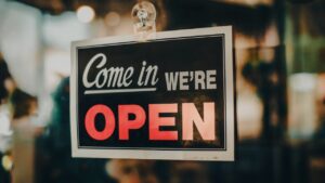 Open for business sign on store depicting how owners can protect their business assets with background checks