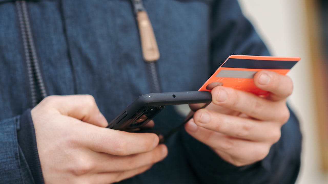 Man holding cellphone to do identity verification to prevent credit card fraud