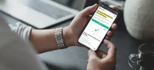 Man holding cellphone browsing Certn background checks online