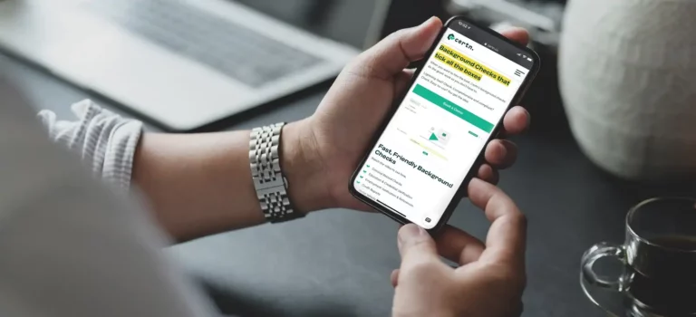 Man holding cellphone browsing Certn background checks online