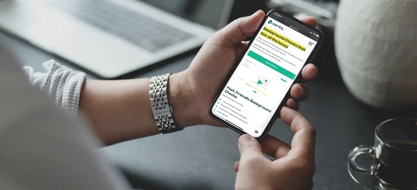 Man holding cellphone browsing Certn background checks online