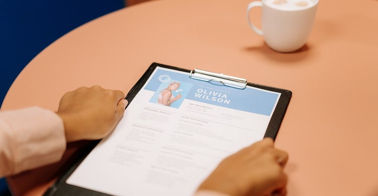 A job application on a table that needs how verifications stop application fraud to be vetted before hiring