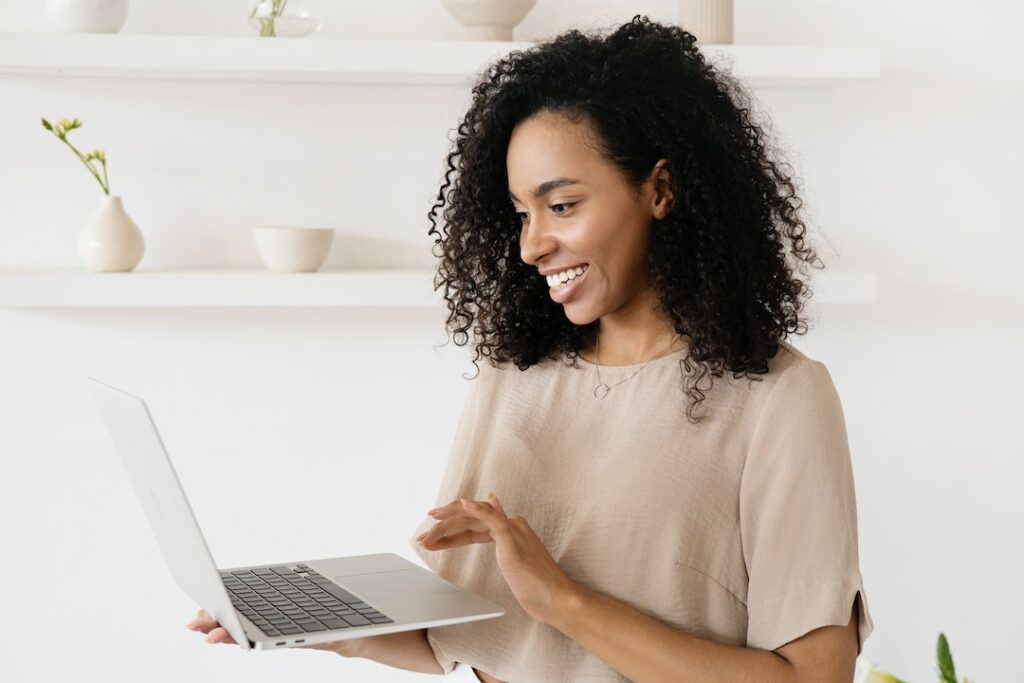 Happy female candidate with laptop showing positive candidate experience with technology