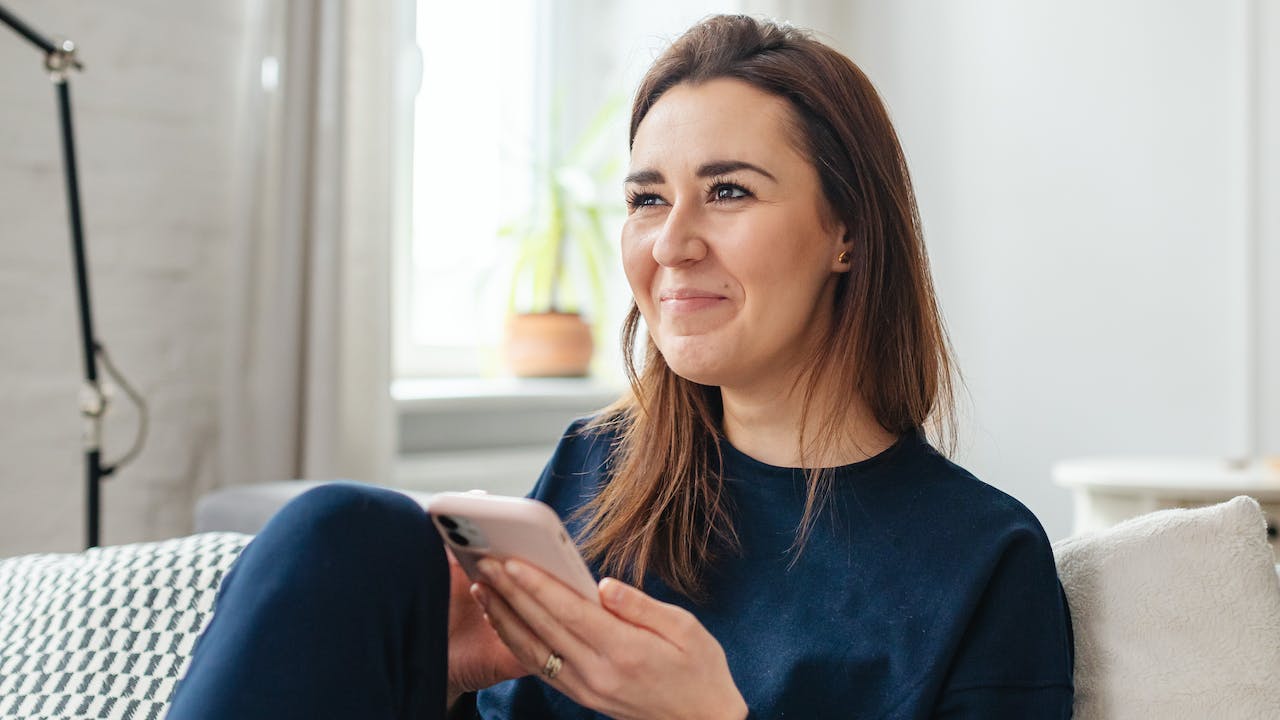 Woman running an online check on smartphone to show how to run a background check on yourself