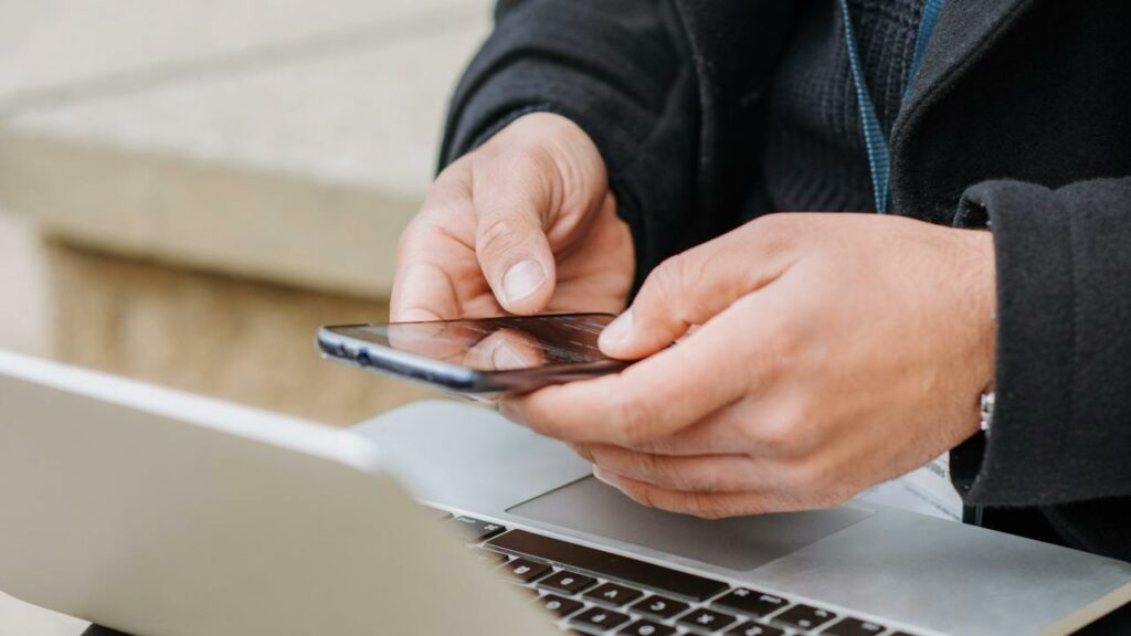 Looking up someone's criminal record check Alberta online on laptop and smartphone