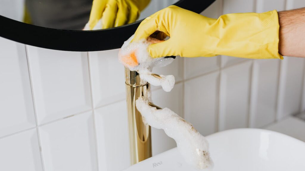 Cleaner washing bathroom sink demonstrating best background checks for your cleaning business