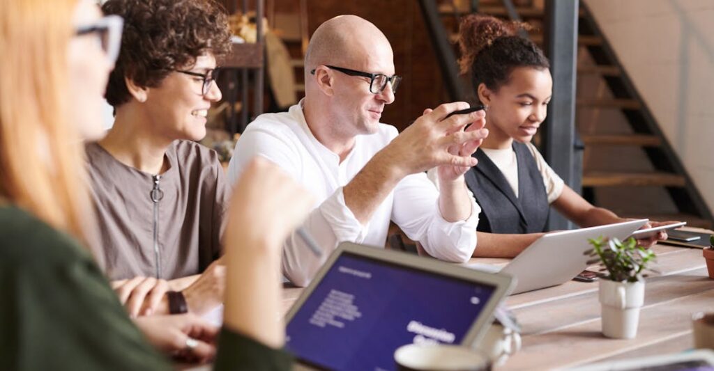 Happy collaborative workplace with diverse colleagues at conference table about to dive into background check terms