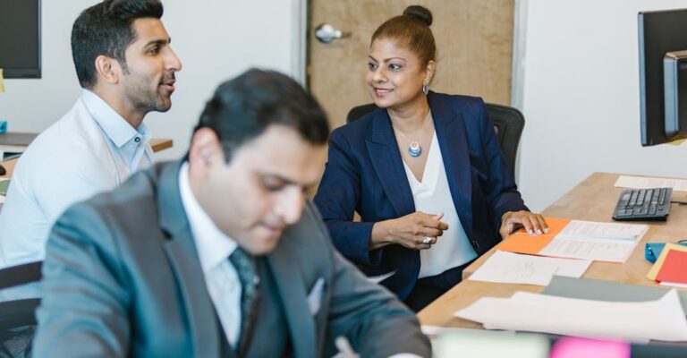 Colleagues collaborating at desk in a safe and relaxed setting thanks to employment background checks and employee screening