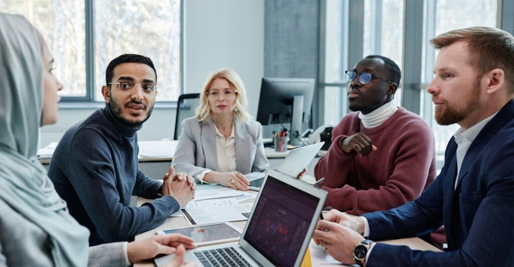 Diverse employees collaborating in an office to showcase benefit of global hiring