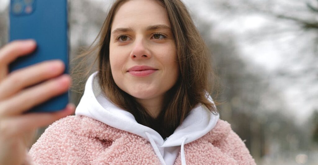 Smiling woman taking a realtime selfie representing liveness detection in digital identity verification trends