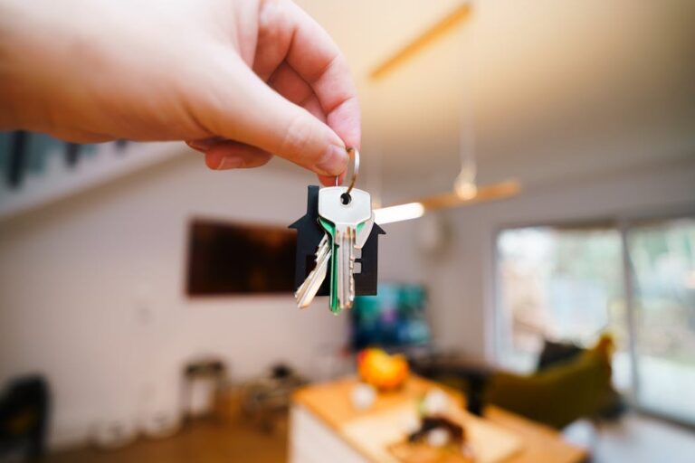 A hand holding keys to rental property after successful tenant screening services