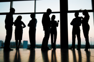 Silhouettes of professionals collaborating, representing global hiring and background screening at scale in India