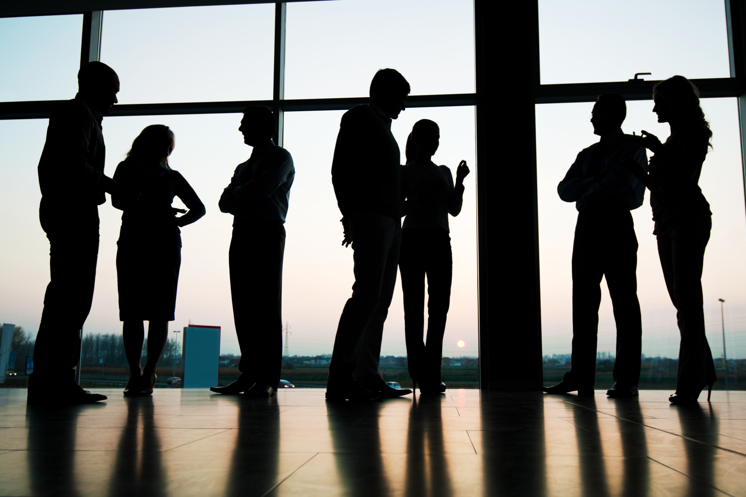 Silhouettes of professionals collaborating, representing global hiring and background screening at scale in India